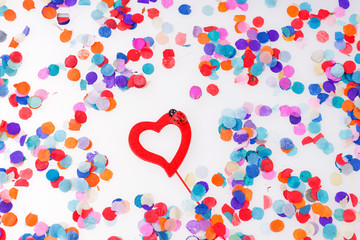 Colorful confetti with red heart on white background