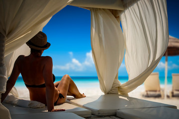 A woman relaxing in the sunshine and looking at beautiful beach and ocean and mountains