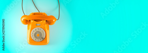 Cuadros en Lienzo A orange vintage dial telephone with blue background.