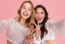 Smiling Friends Women Posing Isolated Over Pink Wall Background Take Selfie By Camera.