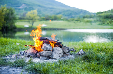 Burning coal in the bonfire. Burning fire in nature on the background of the lake The embers in the fire.