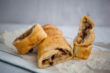 Wall Mural - strudel with apple and cinnamon on a light towel, light background