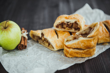 Wall Mural - strudel with apple and cinnamon on a light towel, light background