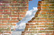 Through a crack of a brick wall you see the sky - escaping concept image
