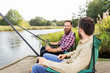 © Syda Productions - leisure and people concept - male friends fishing and drinking beer on lake