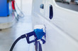 © Koonsiri - Hand refilling the white van with fuel at the gas station. Oil and gas energy.