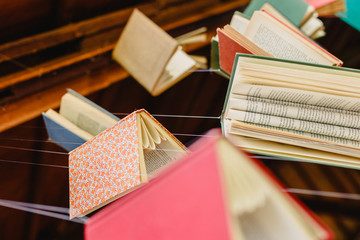 Wall Mural - Old books hung with strings to encourage reading and learn about culture.