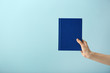 © Pixel-Shot - Female hand with book on color background