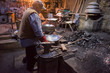 traditional blacksmith manually forging the molten metal