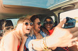 © Zoran Zeremski - Three best friends enjoying traveling in the car, sitting in rear seat and having lots of fun making selfie on a road trip.