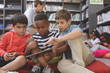 © WavebreakMediaMicro - Schoolboys using a digital tablet while they are sitting on cushions in a library
