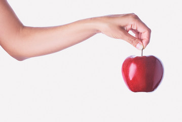 Close up studio shot of female hand holding fresh apple. Isolated on white background.