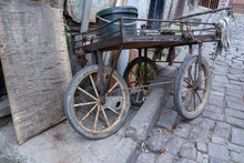 Very Old And Rusty Vendor Wheelbarrow On A Poor Street