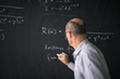 © lightpoet - Math teacher drawing   fuction graph on a blackboard during mathclass (shallow DOF, color toned image)