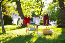 Clothes And Toys Hanging On The Clothesline In The Summer Outdoors. Accessories To Washing