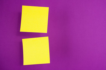 Two yellow paper stickers hanging in the air (levitate) on a purple background