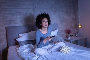 Wall Mural - Woman changing channels on TV