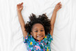 © Lisa Tichané - Little girl smiling on white bed with arms up