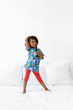 © Lisa Tichané - Young girl standing on bed singing with hairbrush as a microphone