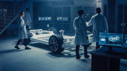 Fototapete - Team of Automotive Engineers and Scientists Discussing, Designing and Working on Electric Car Platform Chassis Prototype. Using 3D CAD Software, Analysing Efficiency. Vehicle Frame with Wheels