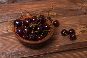 Wall Mural - Fresh sweet sweet cherry in a plate on a wooden background.
