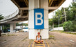 © Artem Markin - Modern girl sitting on a road marking. Carries a yellow backpack. Tattooed hands