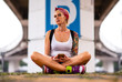 © Artem Markin - Modern girl sitting on a road marking. Carries a yellow backpack. Tattooed hands