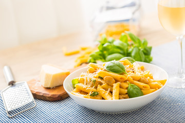 Wall Mural - Pasta penne with chicken pieces mushrooms basil parmesan cheese and white wine.  Italian food in white plate on kitchen table