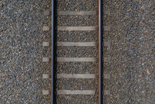Railway Rails With Sleepers On Gravel Close-up Top View