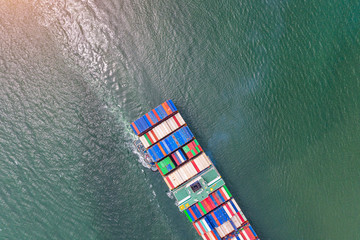 top aerial view of the large TEU containers ship arrival to the port, carriage the shipment from loading port to destination discharging port, transport and logistics services to worldwide