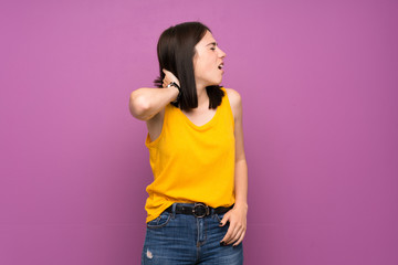 Wall Mural - Young woman over isolated purple wall with neckache