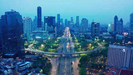 Wall Mural - JAKARTA, Indonesia - July 08, 2019: Beautiful aerial landscape of the new Semanggi bridge interchange on foggy morning. Shot in 4k resolution from a drone flying backwards