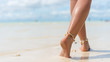 Beach travel concept. Sexy Legs on Tropical Sand Beach. Walking Female Feet. Closeup