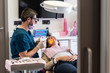 © Cavan Images - Dentist with a precision glsses smiling with patient in dental clinic.