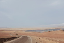 A Dirt Track And Ocean In The Background Against Blue Sky,Paracas,Peru