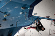 Man sending a difficult route of sport climbing in climbing gym.