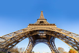 Fototapeta Boho - Up view of the Eiffel tower at the early morning with a clear and cloudless sky