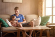 © Cavan for Adobe - Baby boy with his father drinking milk on sofa