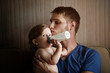 © Cavan for Adobe - Portrait of father sitting with baby son (12-17 months) on sofa