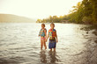 © Cavan for Adobe - Girl (6-7) and boy (8-9) holding hands in lake