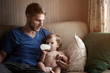 © Cavan for Adobe - Baby boy with his father drinking milk on sofa