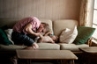 © Cavan for Adobe - Father kissing his son's feet on sofa