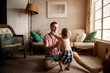 © Cavan for Adobe - Smiling father playing with his son at home