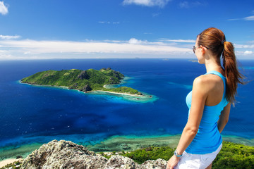 Wall Mural - Young woman standing on top of Vatuvula Volcano with a view of Kuata Island, Wayaseva Island, Yasawas, Fiji