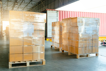 Wall Mural - Packaging Boxes Wrapped Plastic Film on Pallet Loading into Shipping Cargo Container. Supply Chain. Trucks Parked Loading at Dock Warehouse. Shipment Logistics. Cargo Freight Truck Transport.	