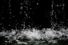 Movement Of The Water Splash On Black Background. Water Drop From The Fountain. Can Use For Add Text And Abstract Background.