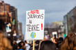 French sign held at ecological protest. A French sign is viewed close-up above the heads of environmental demonstrators, saying Alert, save the earth during a gathering in a city center.