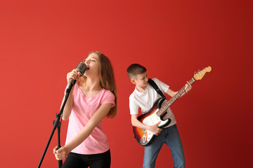 Wall Mural - Little musicians playing against color background