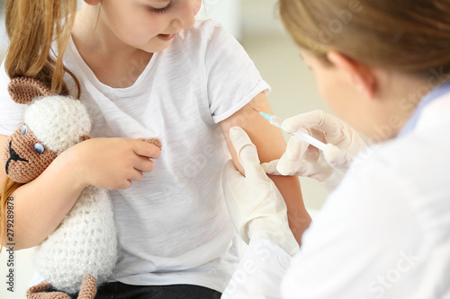 Fotografía  Doctor vaccinating little girl in clinic