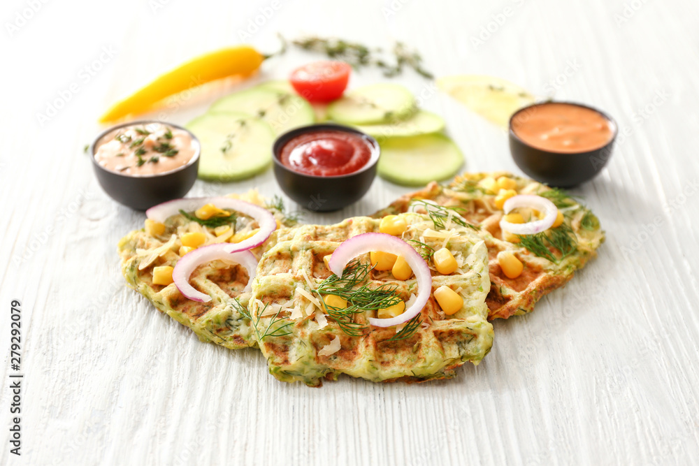 Tasty squash waffles with sauces on white table